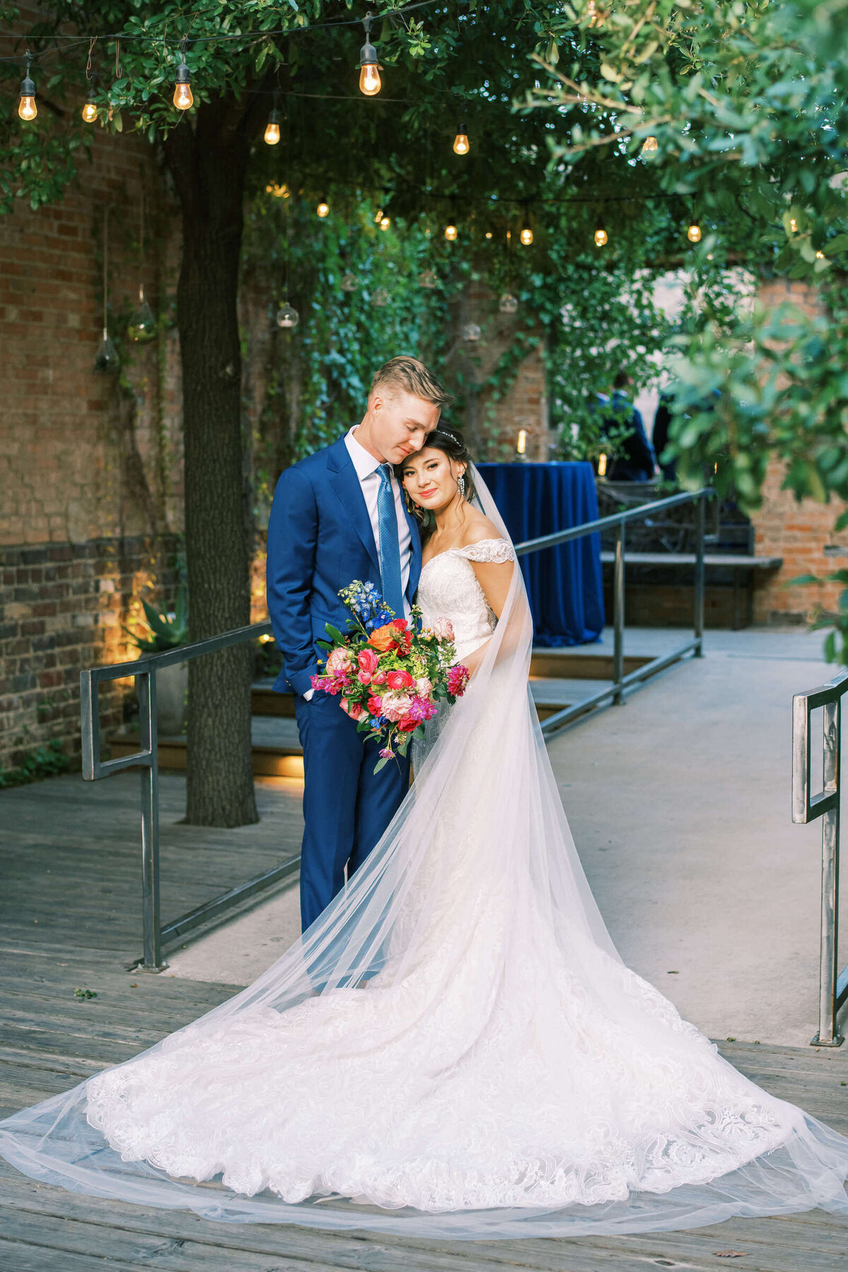 Bride and groom stand outside in elegant courtyard at The 4Eleven in Fort Worth