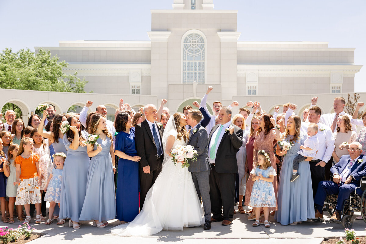 The bride and groom share a kiss as all of their closest family and friends surround them and cheer for them!