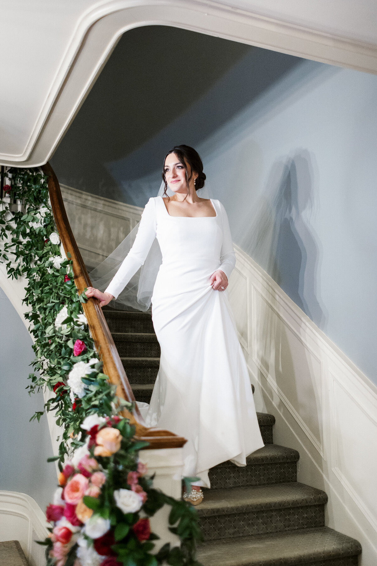 Bride is walking down the stairs with joy to see her groom