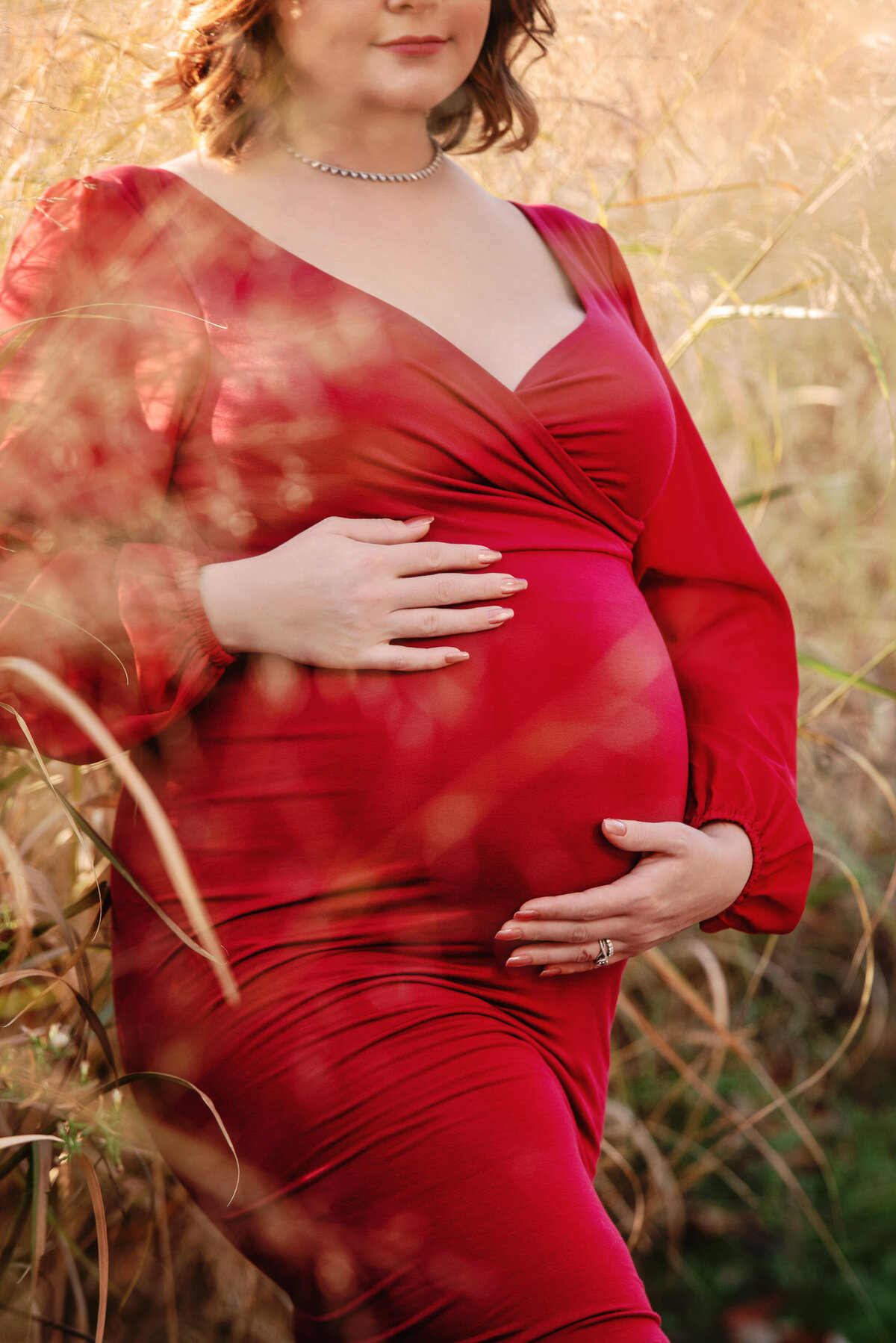 st-louis-maternity-photographer-close-up-of-pregnant-mom-in-burnt-orange-dress-standing-in-tall-grass