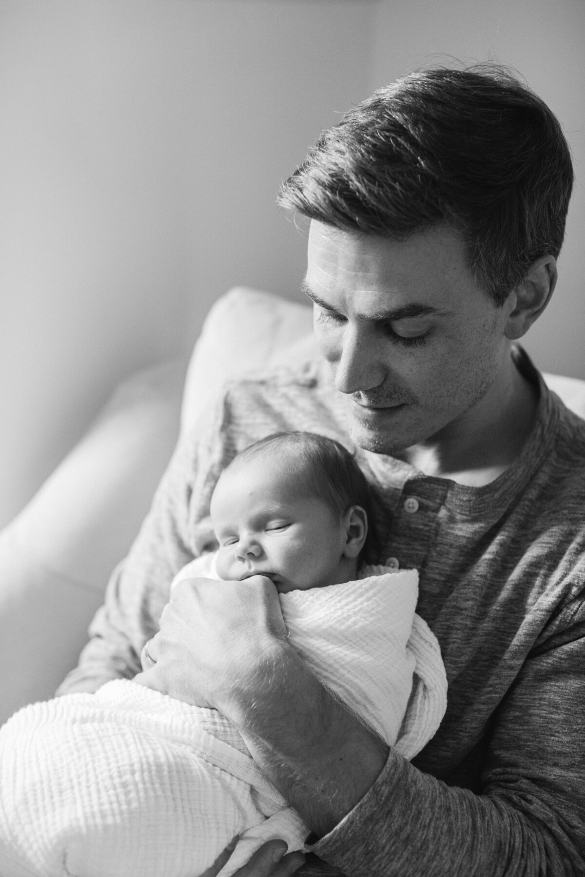 black and white photo of dad holding baby by new hampshire newborn photographer
