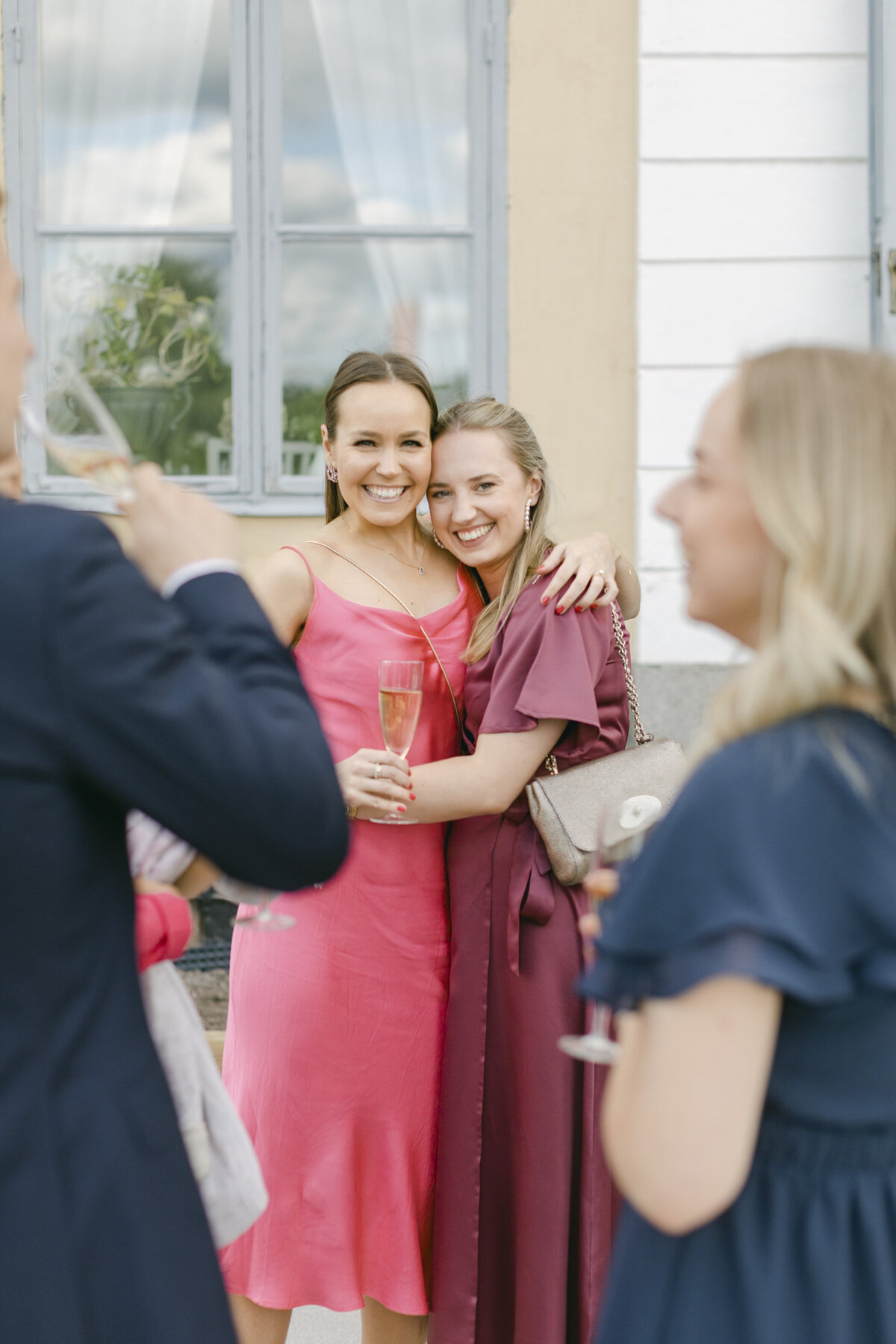 Bröllopsgäster ler in i kameran på terrassen på Schenströmska