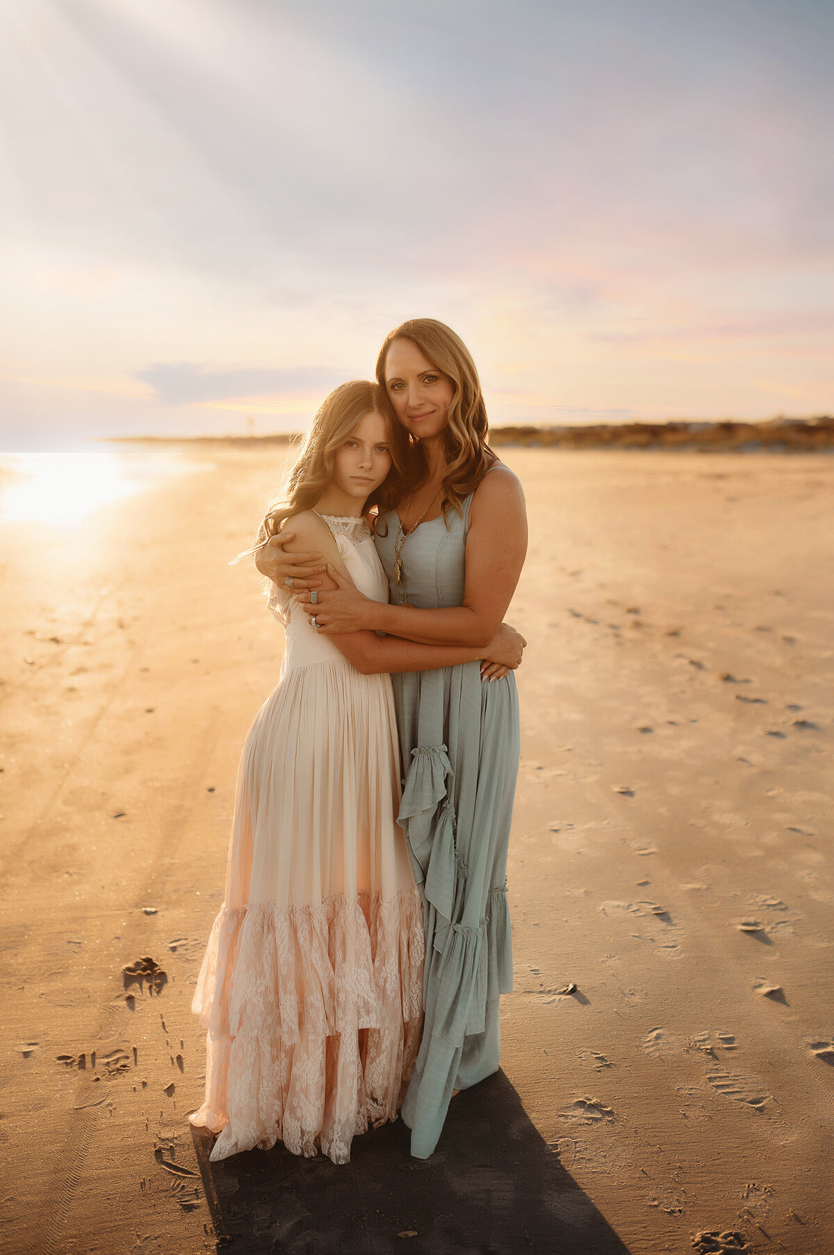 Mother embraces her daughter for Family Pictures on the Beach in Isle of Palms, South Carolina.