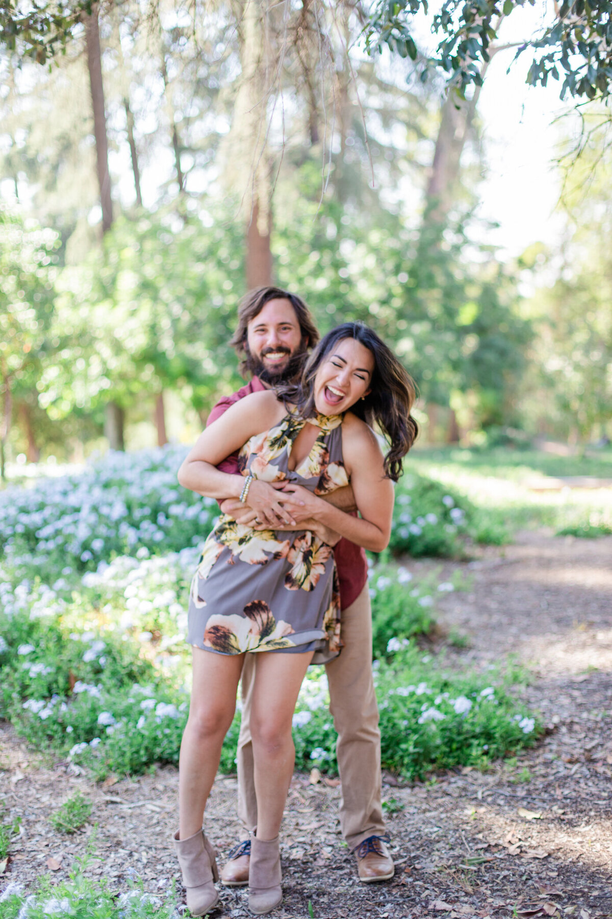 engaged couple laughs in the park