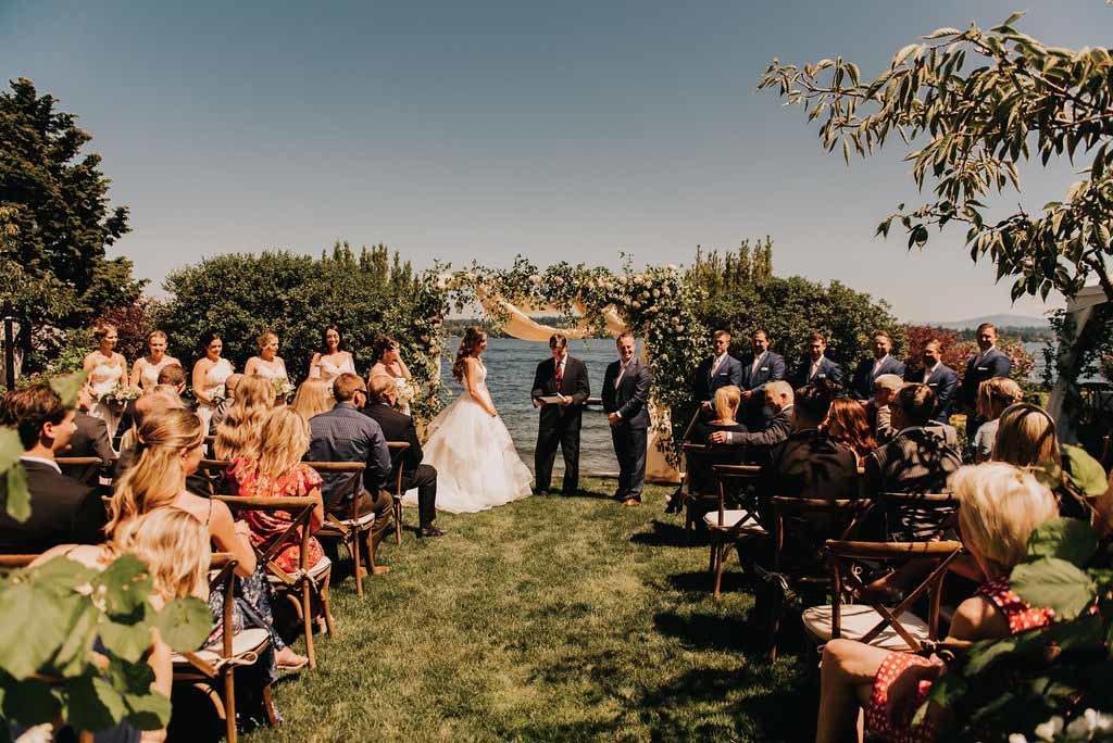 wedding at the shores of Lake Washington with large flower arch in background