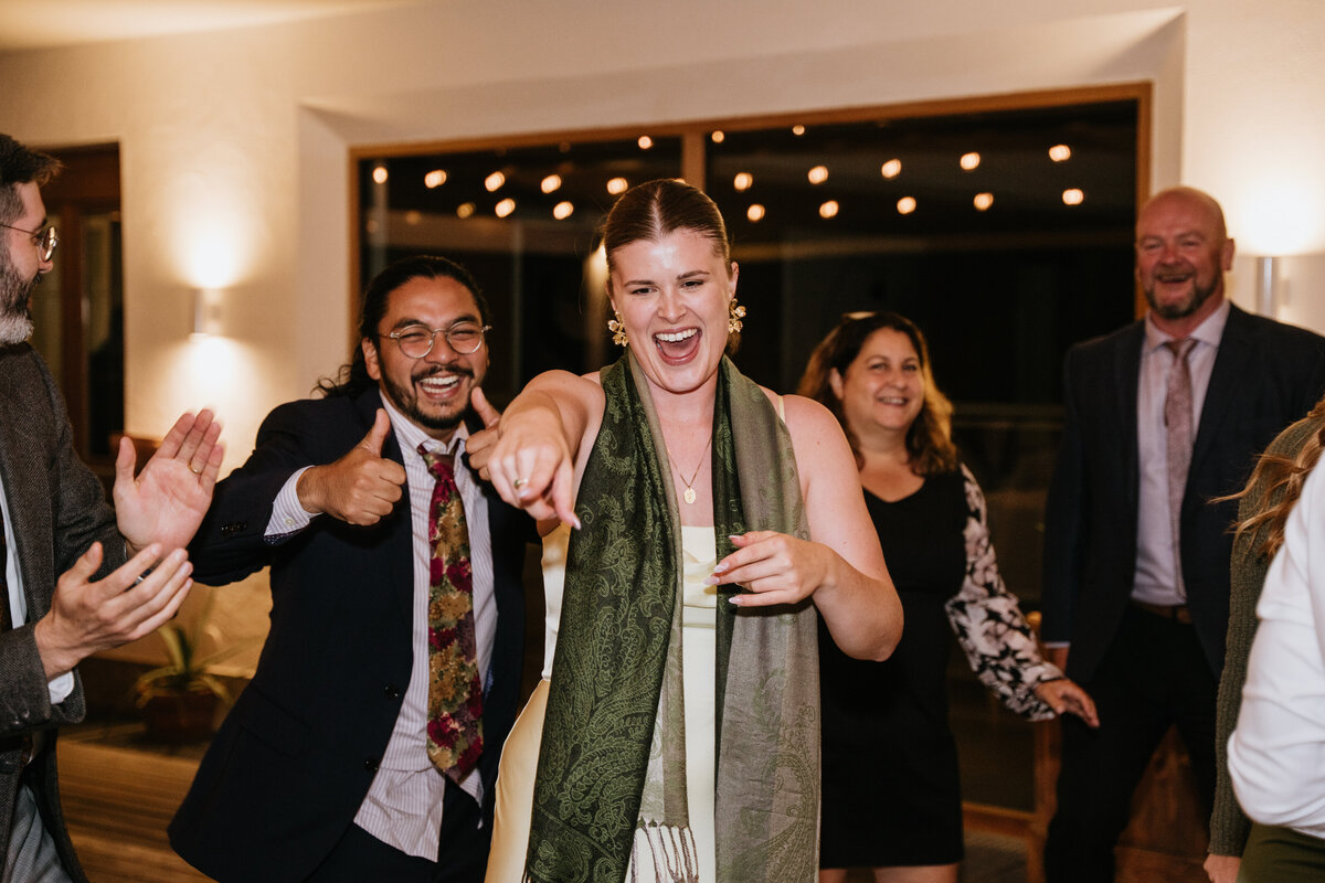 Wedding guests dancing energetically outdoors
