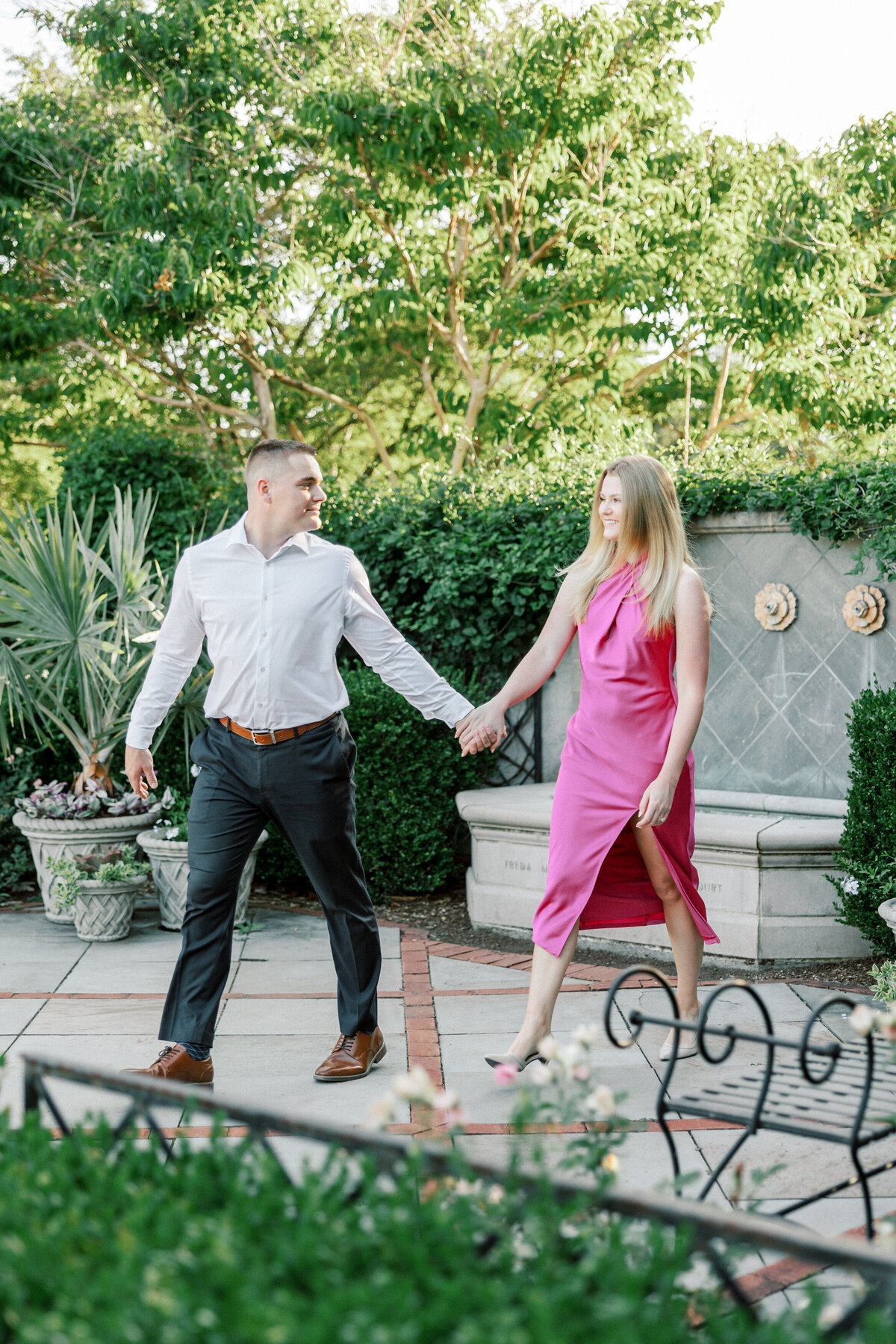 Couple walking away from stone fountain in Columbus park shot by Philadelphia wedding photographer.