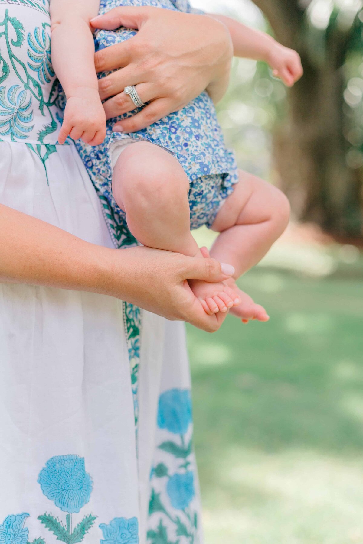 Mom holding baby girl’s feet during family photo session in Palmetto Bluff, Bluffton, SC for Hilton Head Photographer Lamp and Light Photography.