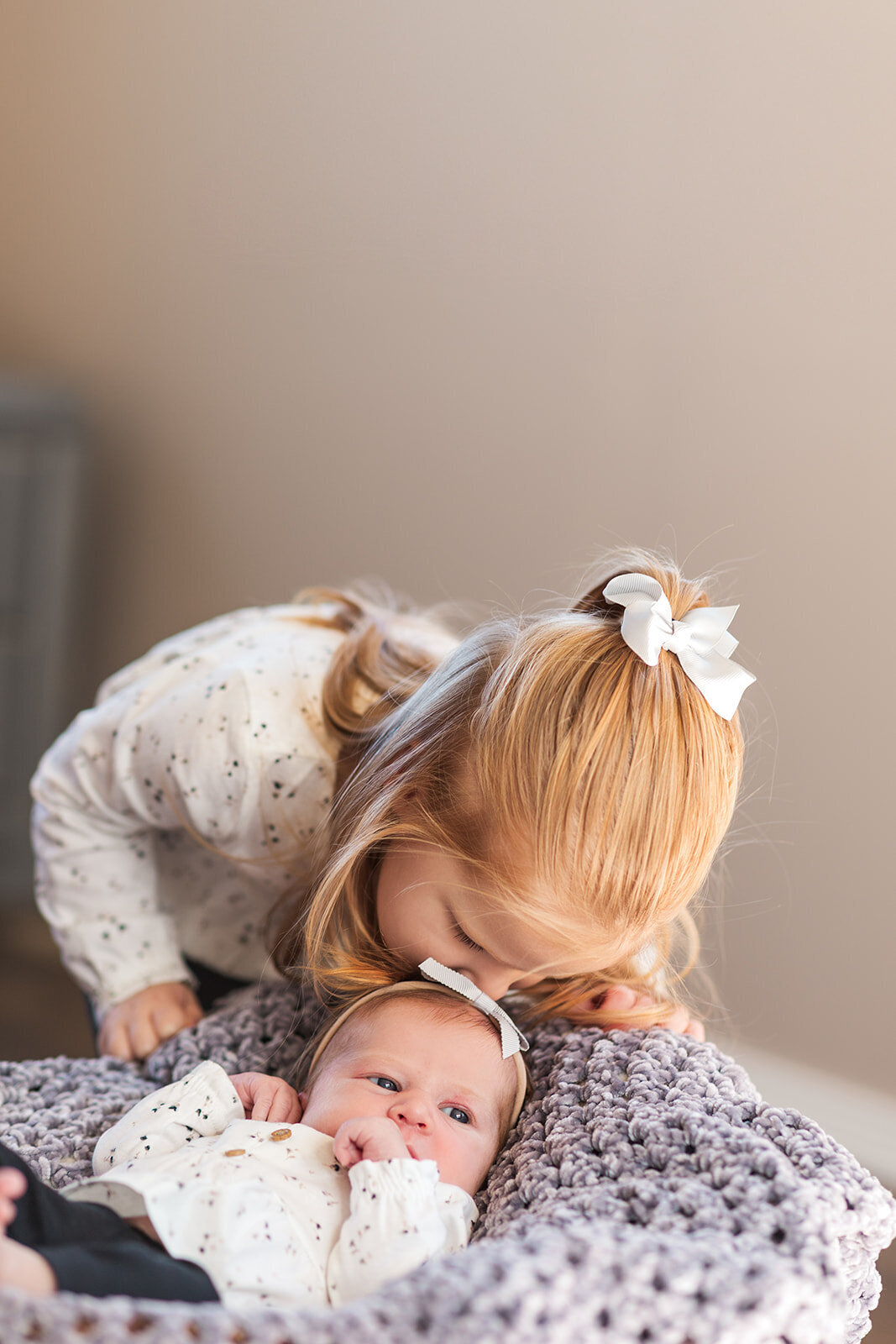 Big sister kiss with newborn in Columbia home