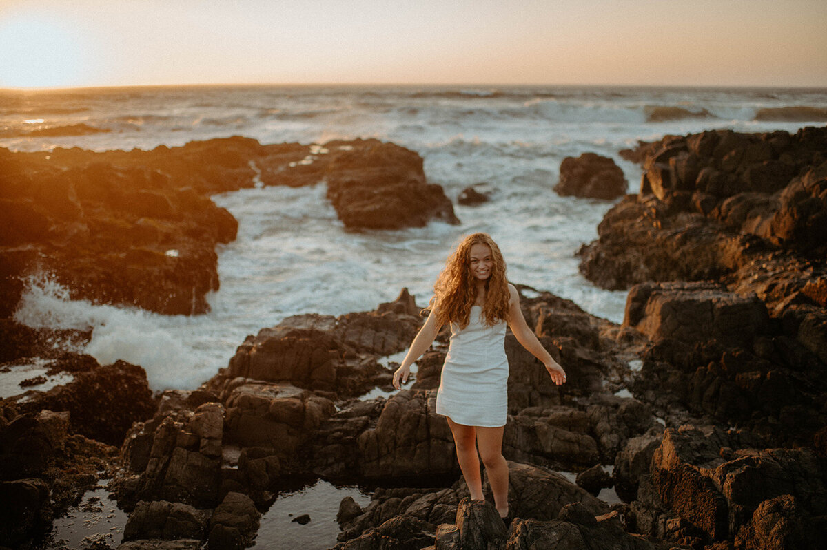 girl standing on Oregon coast in a white dress