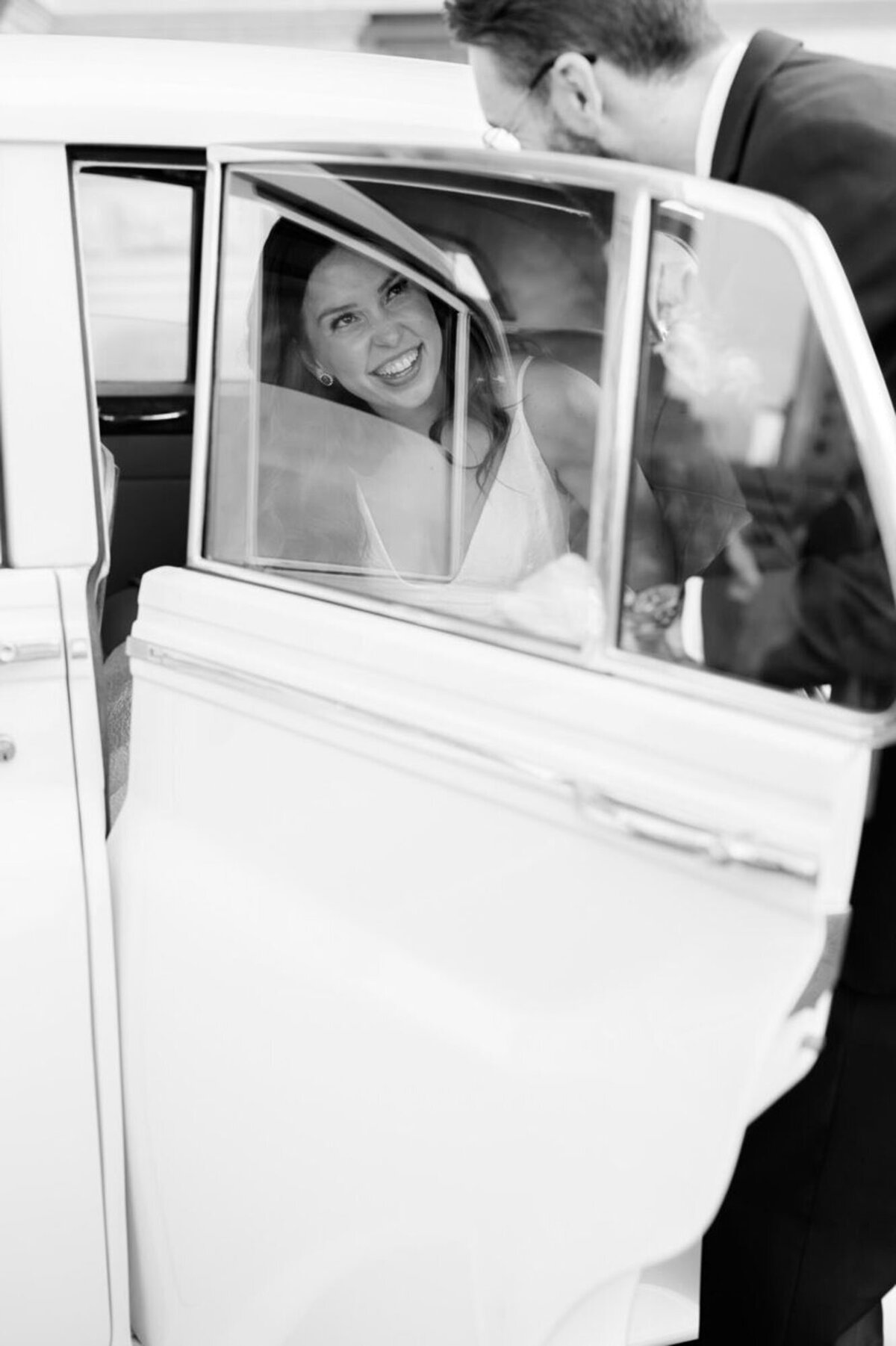 Bride getting into car after wedding in Detroit, MI, by wedding photographer Courtney Rudicel