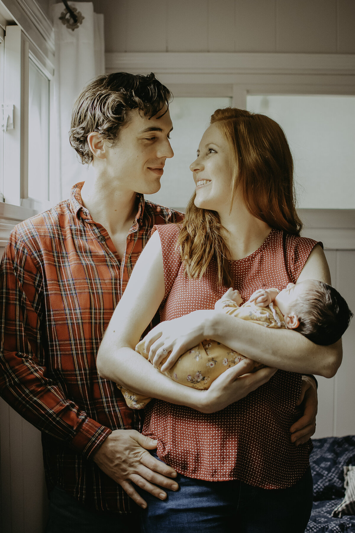 Verona B Photography captures an adorable sleeping newborn baby held lovingly by his mom as she gazes at her husband. It is such an honor to capture these tender moments between new parents in awe of the baby they brought into the world together; in-home newborn session near Akron, Ohio.