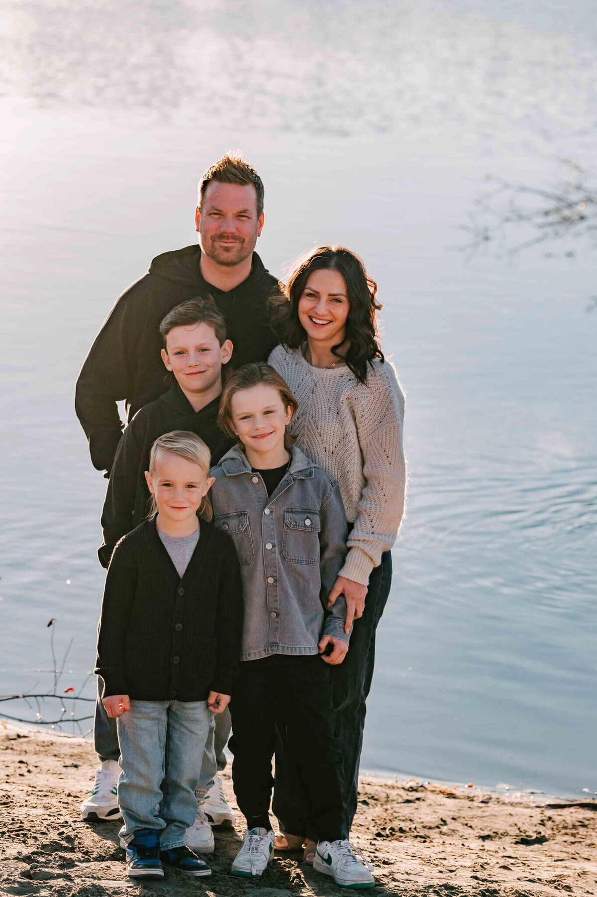 Family of 5 stand together by the river. 