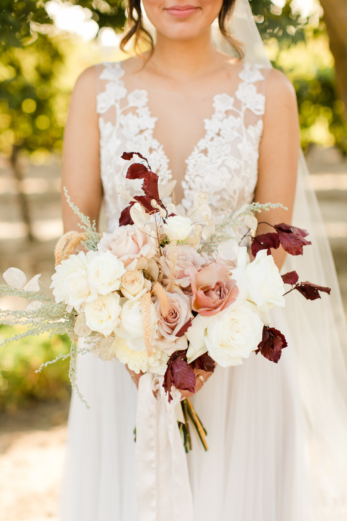 bride holding her bouquet of pink shades