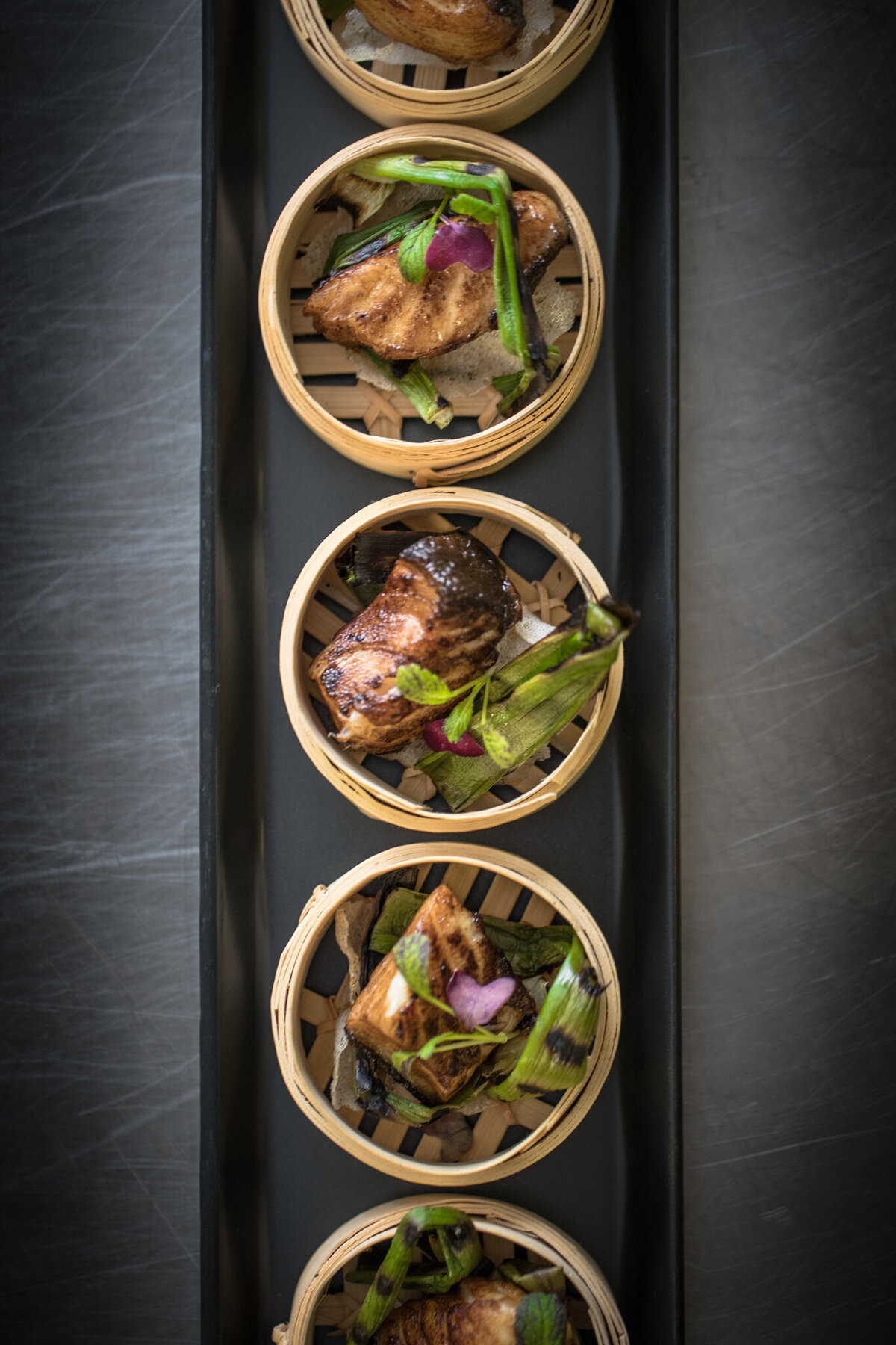 Artisan meal served in bamboo steamer baskets, created by Food Works Craft Catering, contemporary catering in Calgary, Alberta, featured on the Brontë Bride Vendor Guide.