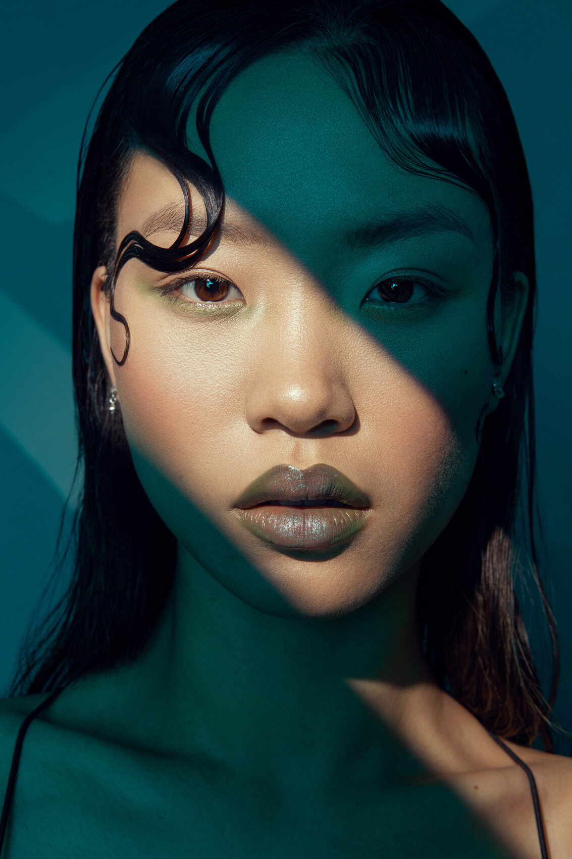 Edgy close-up portrait of Jiaqi with dramatic lighting and minimalist makeup by Ylva Erevall.