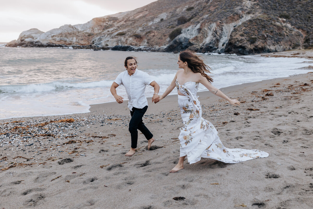 Destination elopement photographer captures couple running through beach holding hands