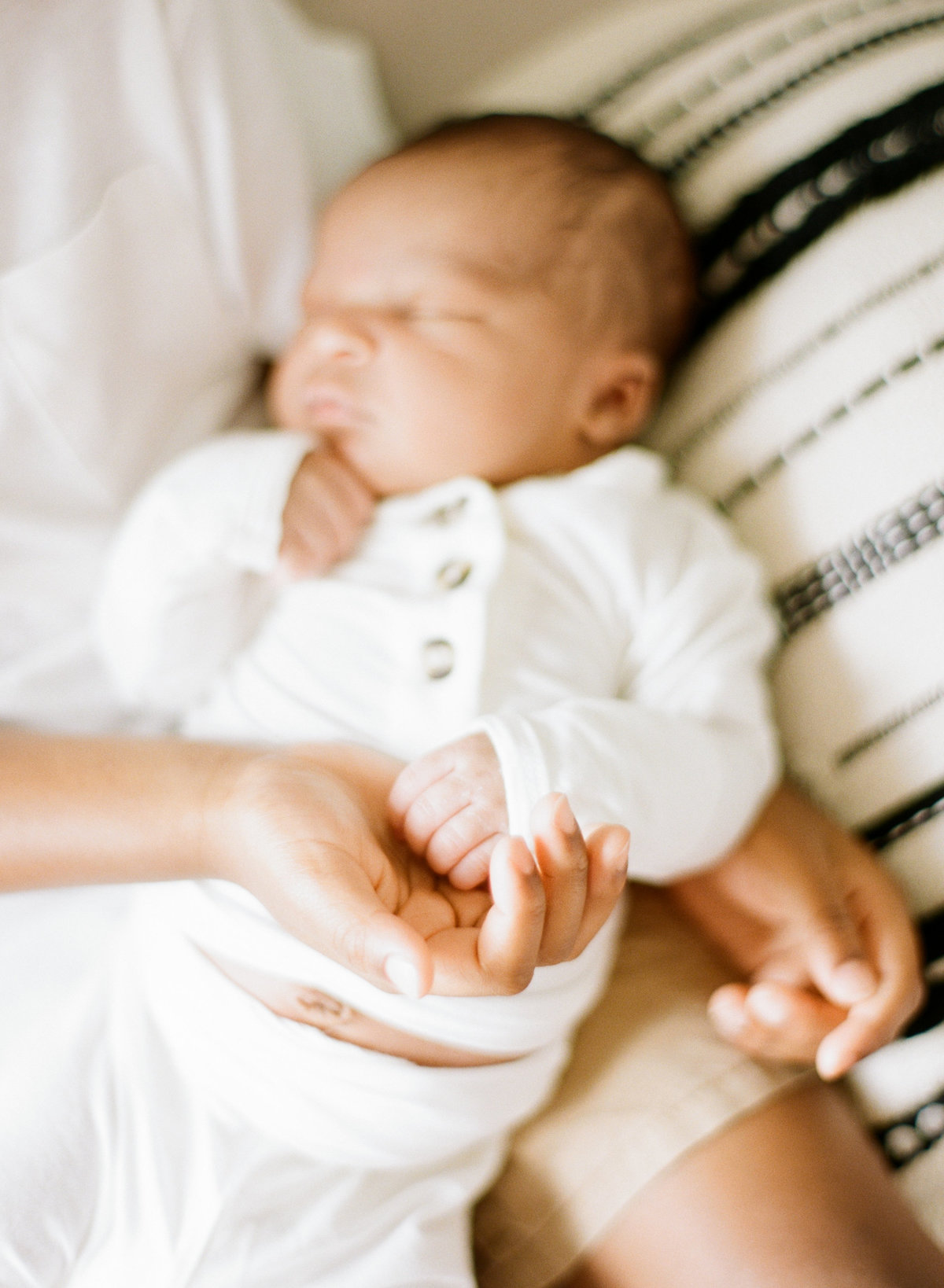 Big brother holds little brothers hand during their Raleigh newborn session .Photographed by Raleigh Newborn Photographer A.J. Dunlap Photography.