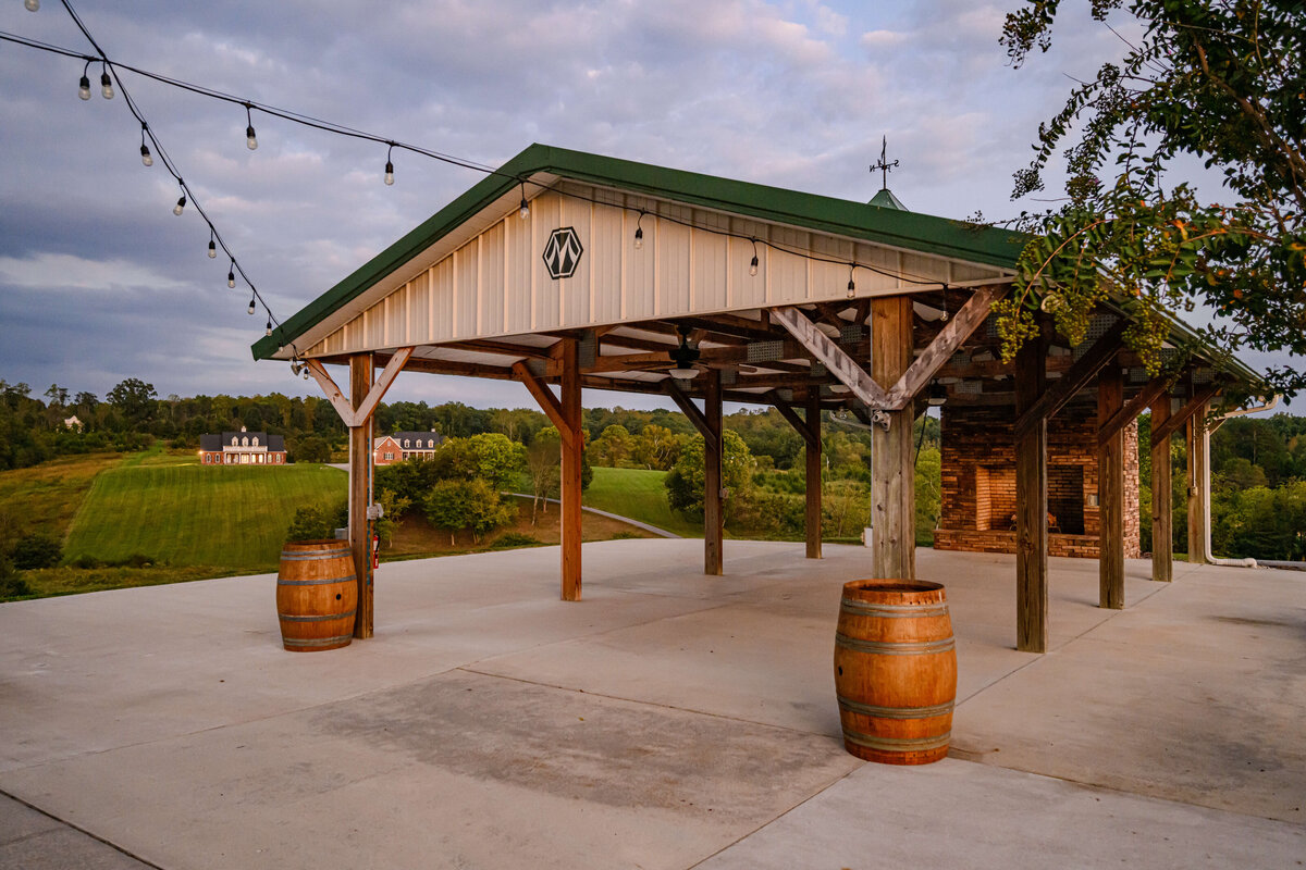 A rustic outdoor pavilion decorated with string lights, overlooking the rolling hills at Willow and Stone Events in Mocksville, NC.