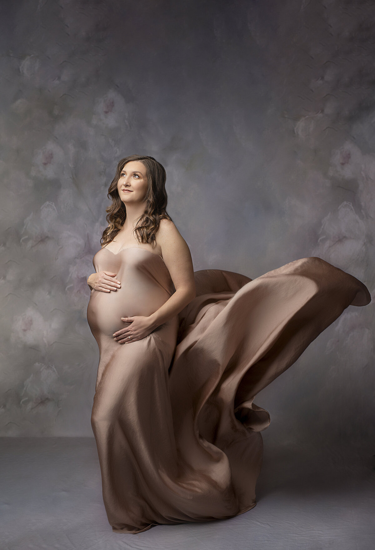 pregnant mother in pink silk dress looking up