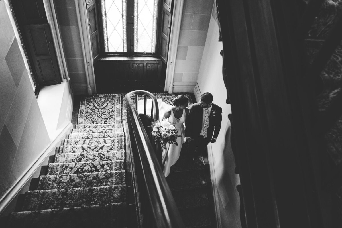 bride and groom spend a quiet moment together walking down the stairs
