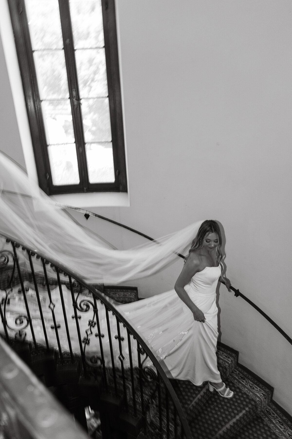 Wedding Photographer & Videographer, black and white image of bride walking down the stairs