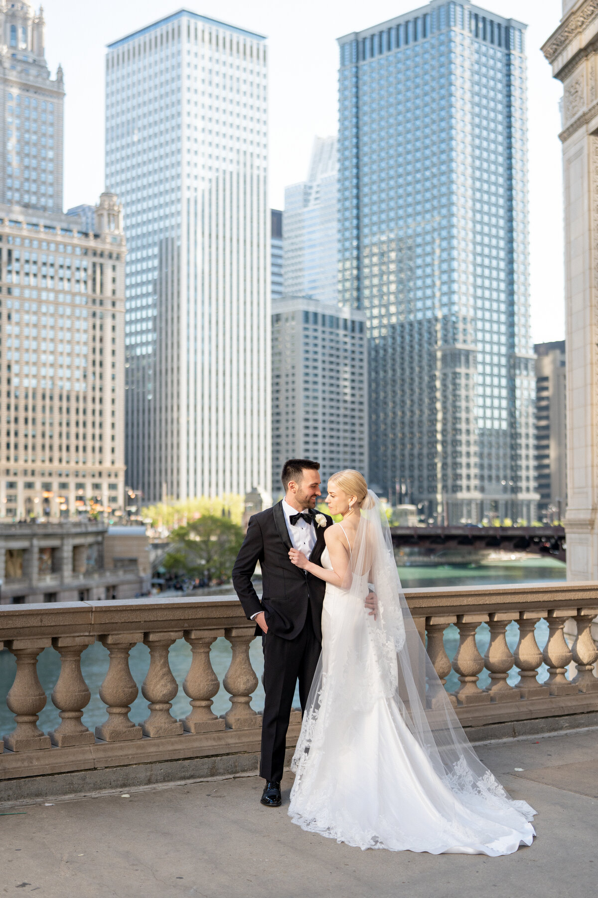 Bride and groom standing at the Wrigley Building in a Gown and Tux, taken by Chicago film wedding photographer Allison Francois