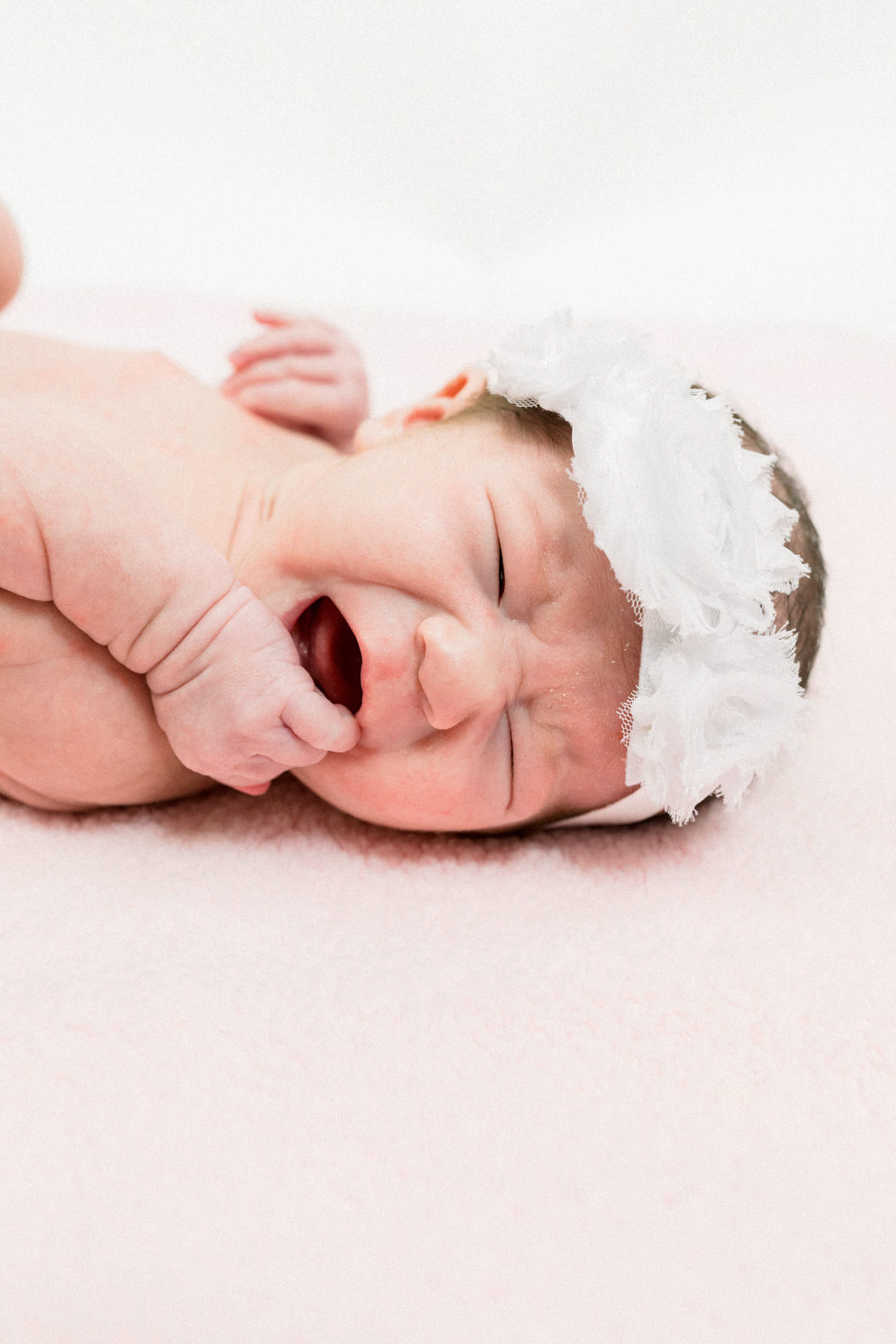 Baby begins to cry during newborn photography session