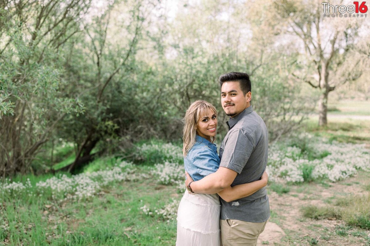 Engaged couple embrace during their photo shoot at Talbert Regional Park
