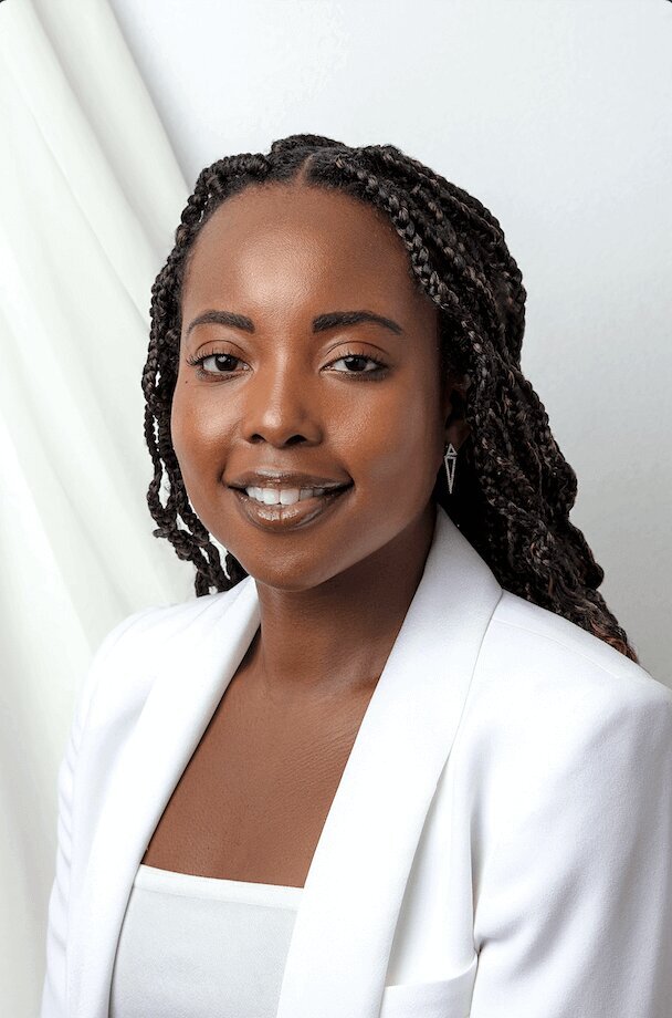 woman wearing white on a white backdrop smiling for a headshot