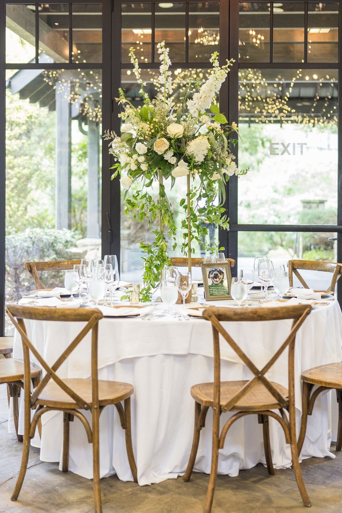 Wedding reception with tall lush white floral centerpieces