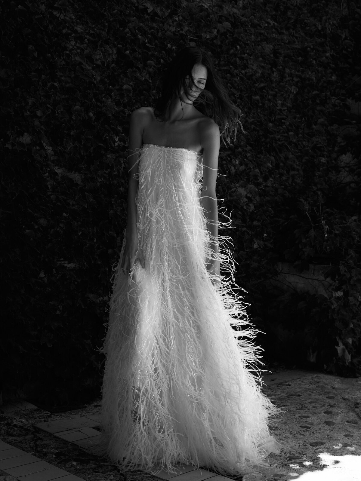 black and white image bride wearing strapless feathered wedding dress