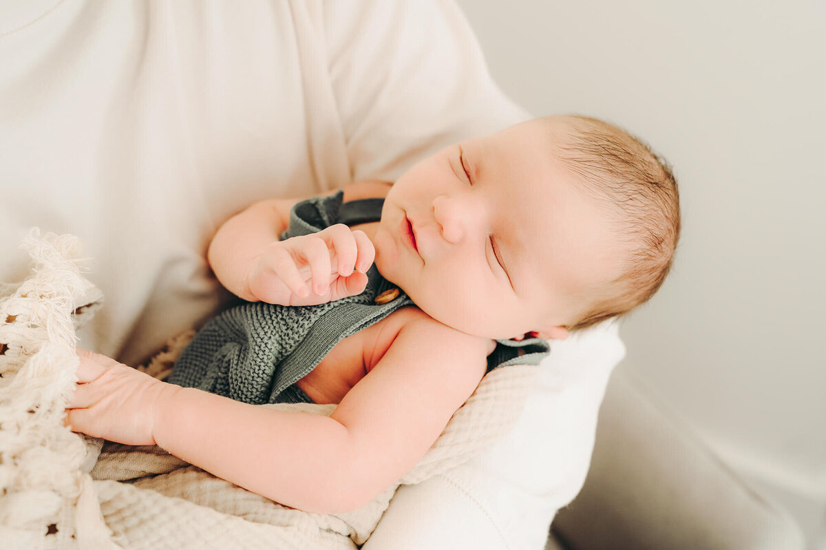 newborn cradled in dad's arms for newborn photos