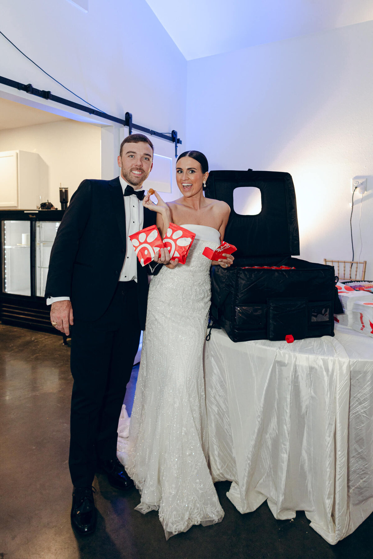 A wedding photo of the bride and groom with their chik-fil-a late night wedding reception snack
