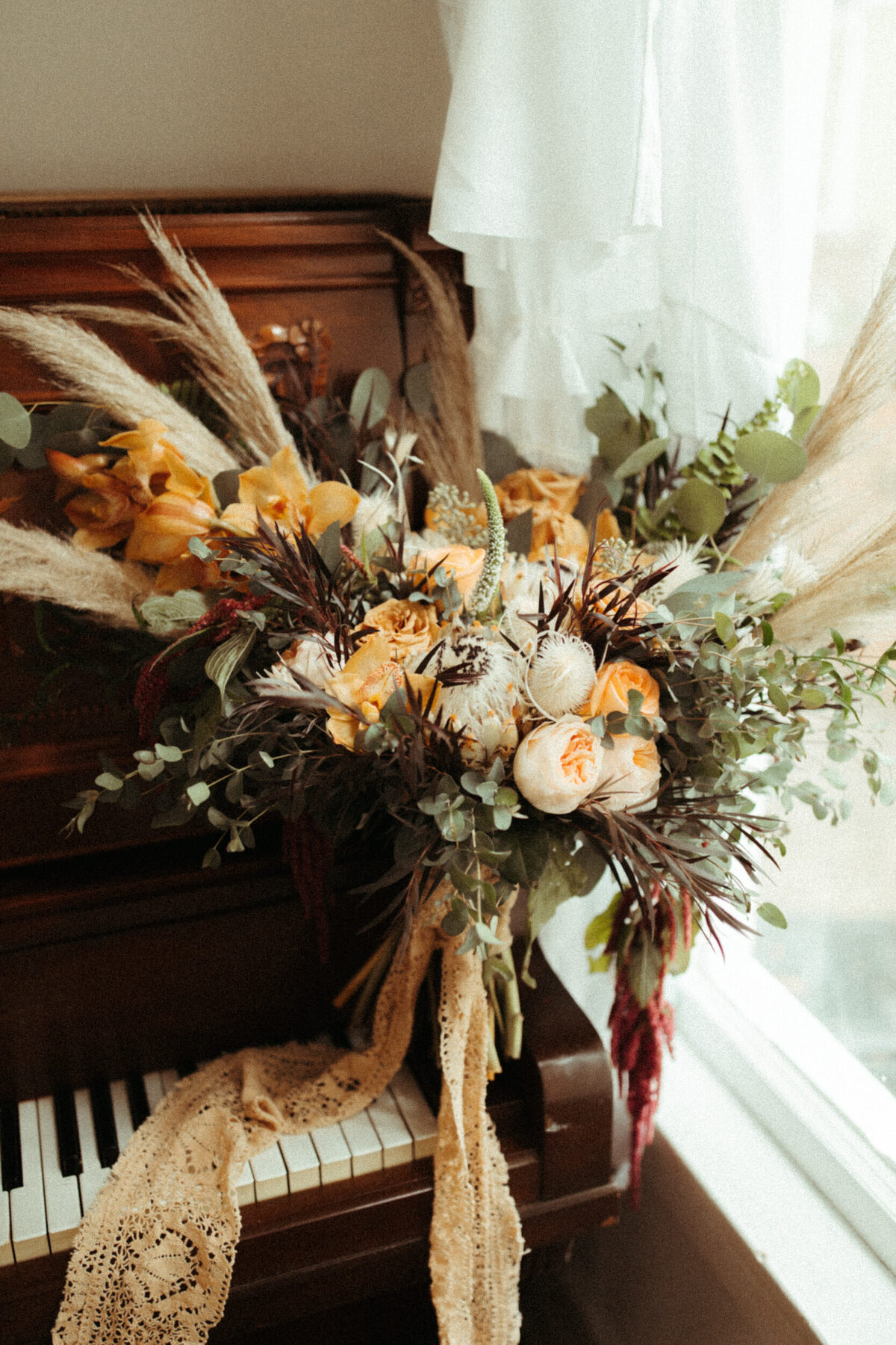 Boho bridal bouquet with vintage lace tied around the base