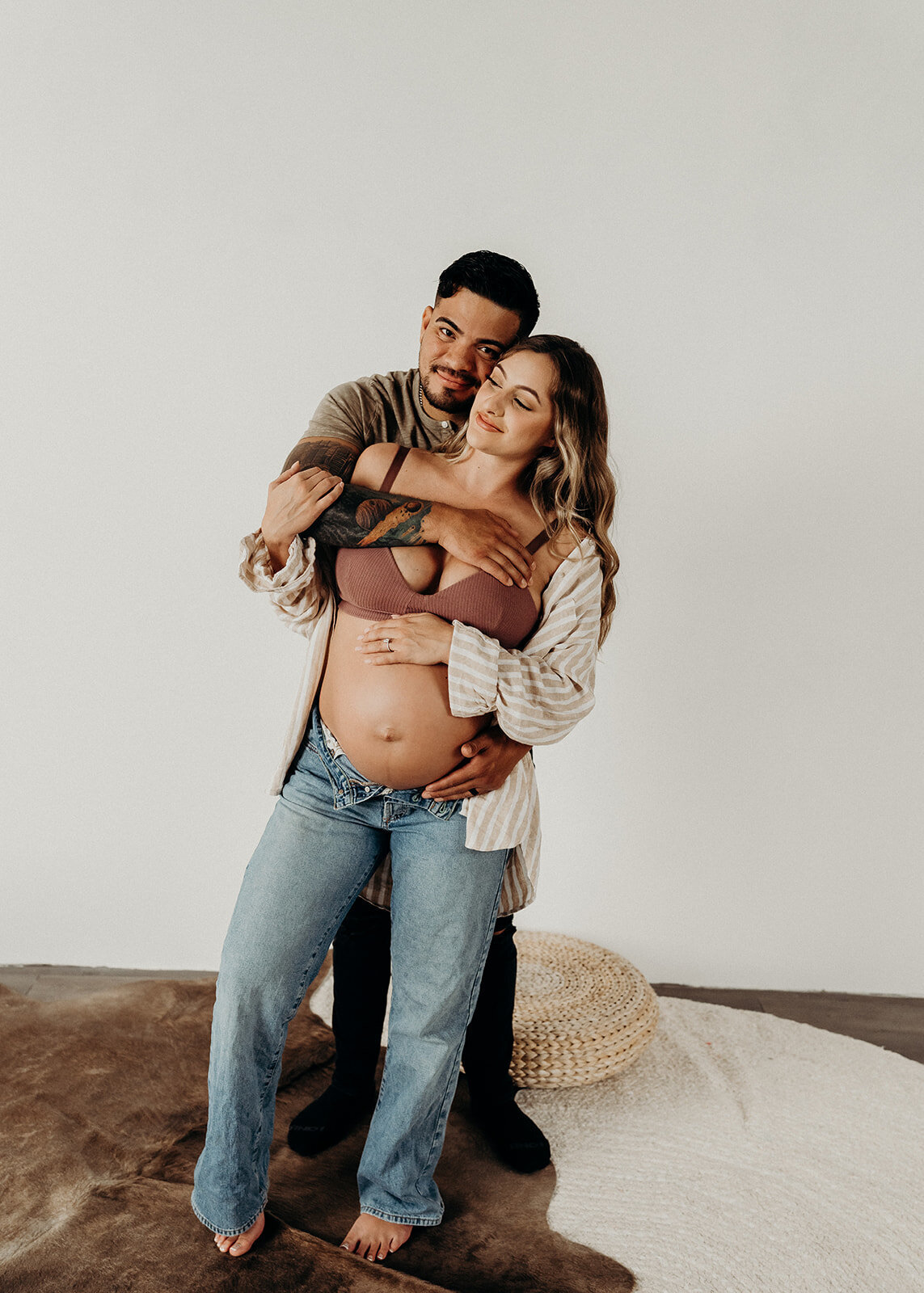 husband playfully holds pregnant wife in minimalist maternity session