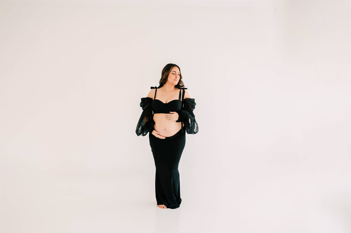 maternity photo of mom holding bare baby bump closing eyes captured by Springfield Mo maternity photographer Jessica Kennedy of The XO Photography