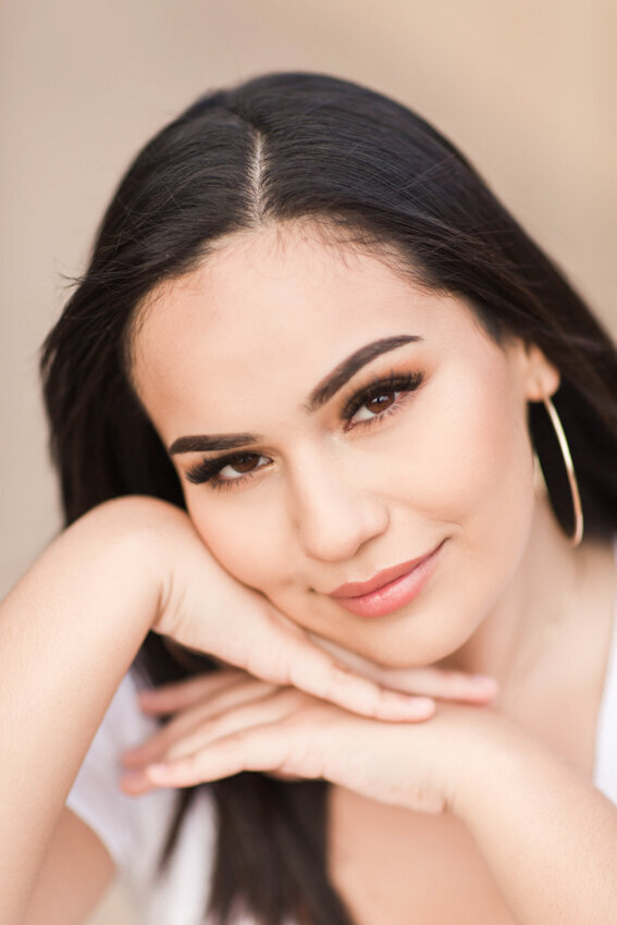 senior girl with head on hands