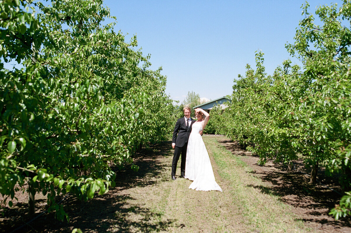 Bride and groom standing in the middle of the Orchard at The Orchard venue.