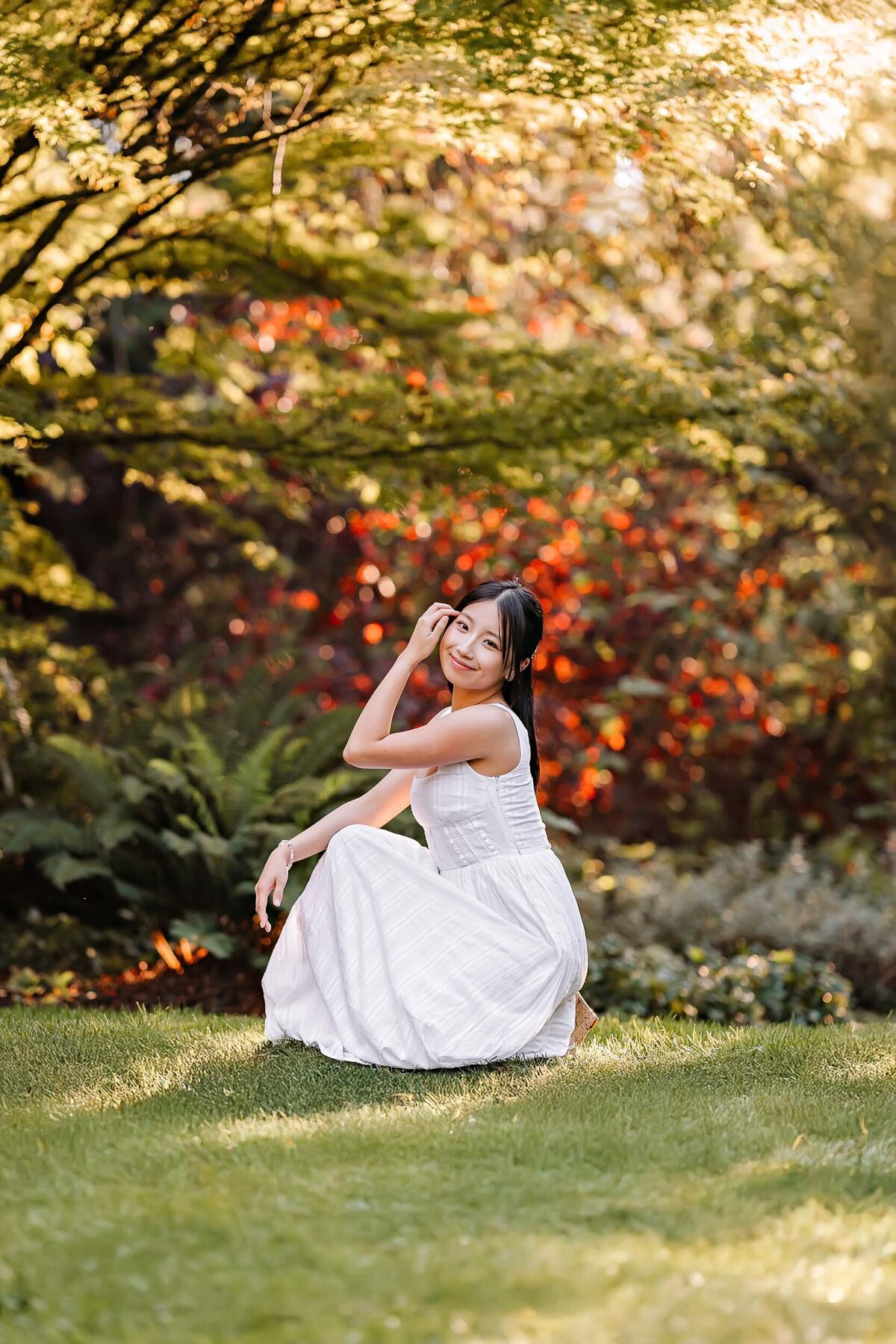 Senior portrait of a girl posing in front of a vibrant fall foliage backdrop, capturing the rich colors of autumn.