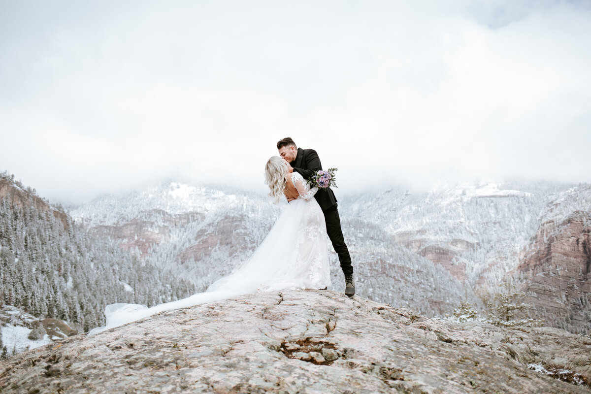 Couple kissing on snowy mountain top in Ouray, Colorado