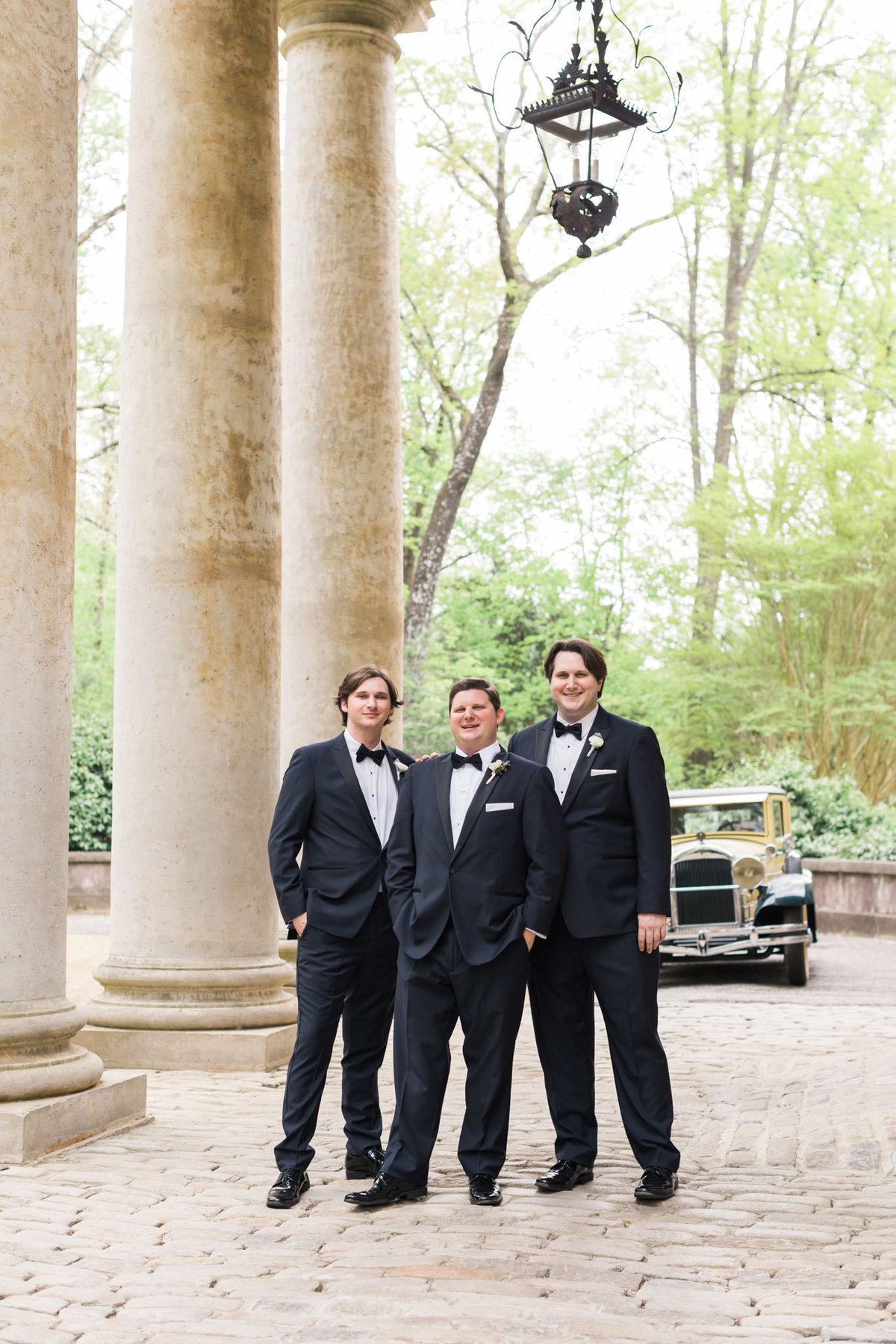 Three brothers have their portrait taken at the front steps of the Swan House. Photo by luxury destination wedding photographer Rebecca Cerasani.