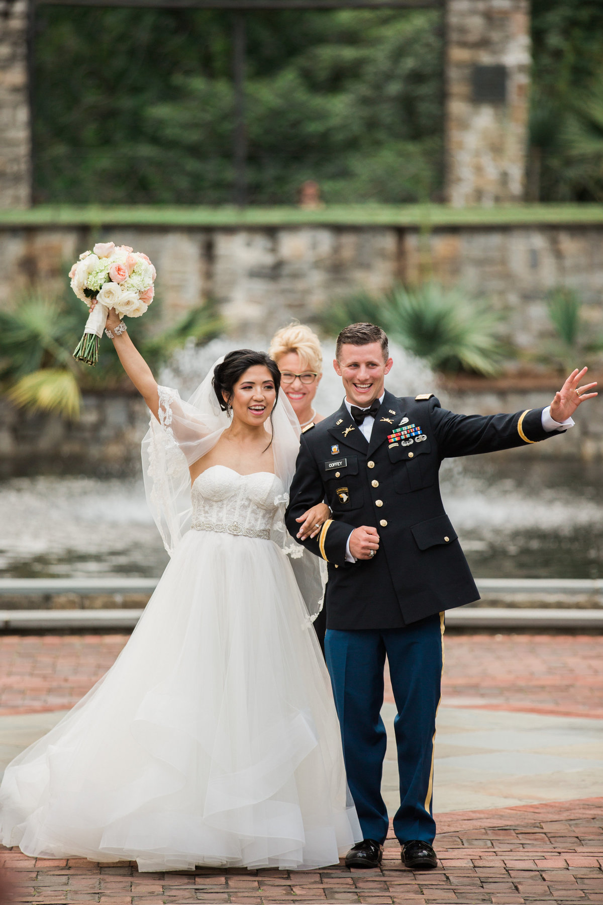 Bride & Groom walk back up the aisle waving at The Norfolk Botanical Gardens