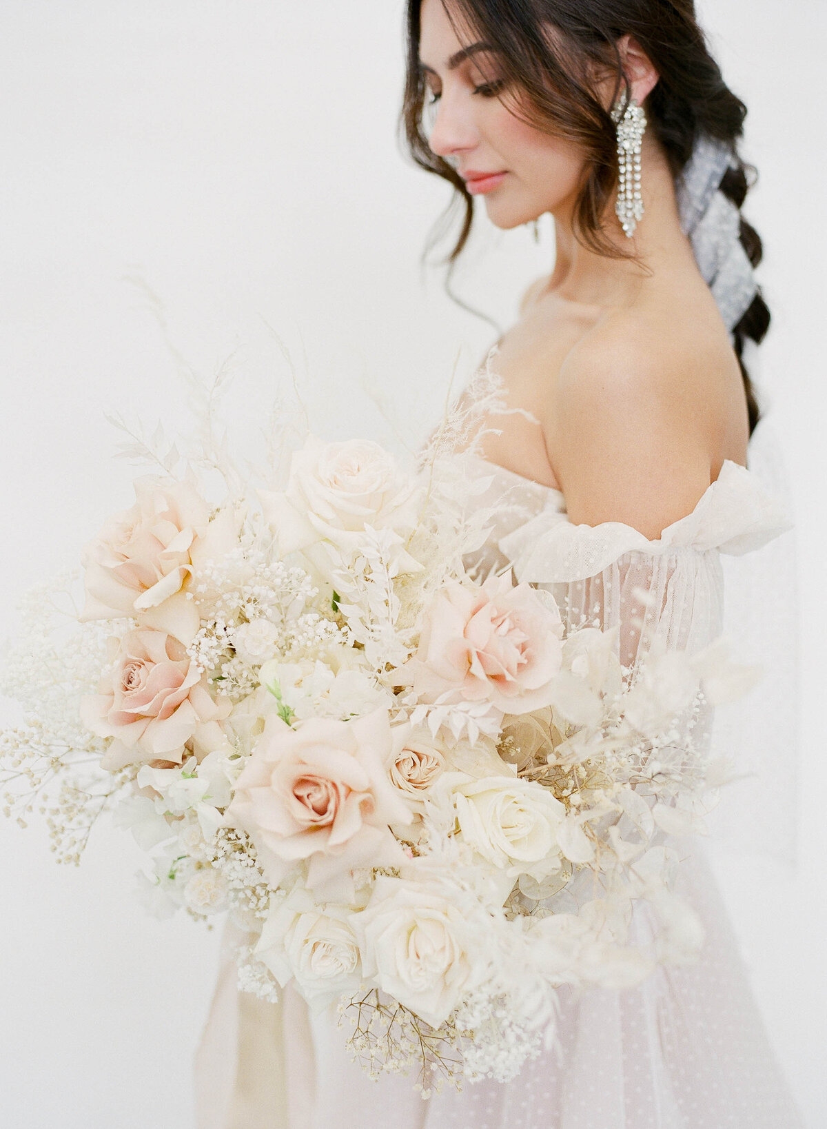 fine art bride with braided hair and blush bouquet
