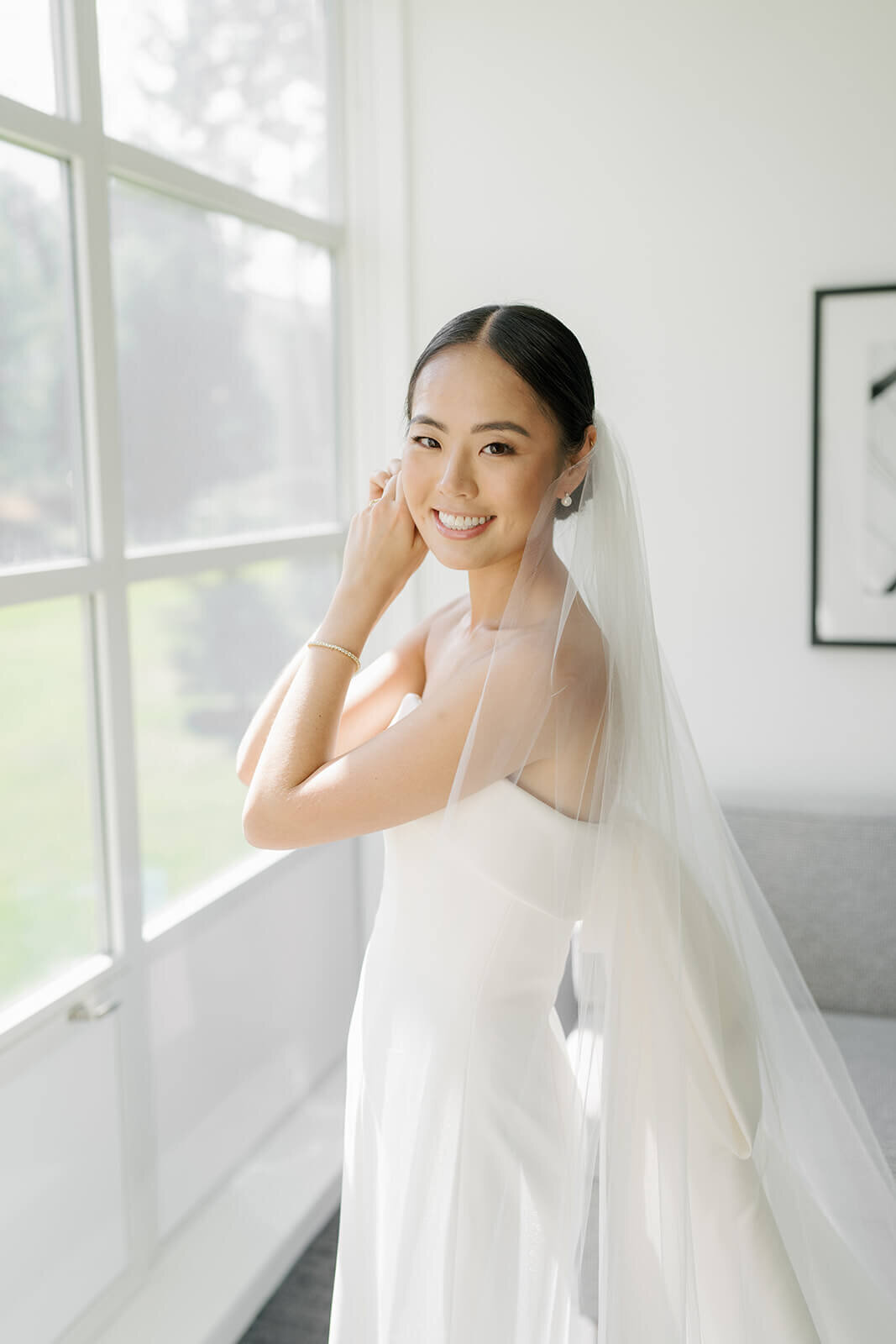 Bride affixes her wedding jewelry in a bridal suite at the Aspen Meadows Resort.