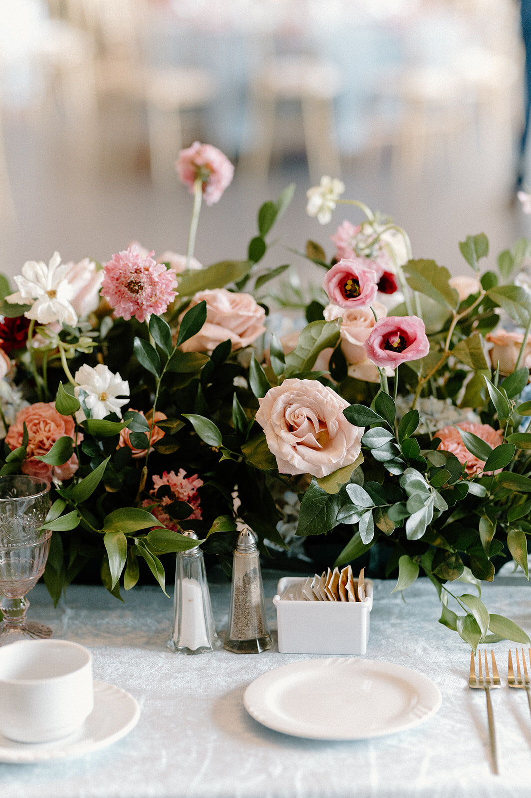 Beautifully decorated wedding tablescape, featuring a lush floral arrangement and elegant place setting. Ideal for classic and romantic wedding themes.