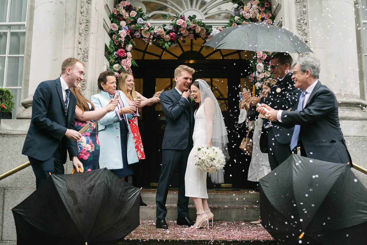 A confetti moment with a bride and groom showered with confetti outside a town hall