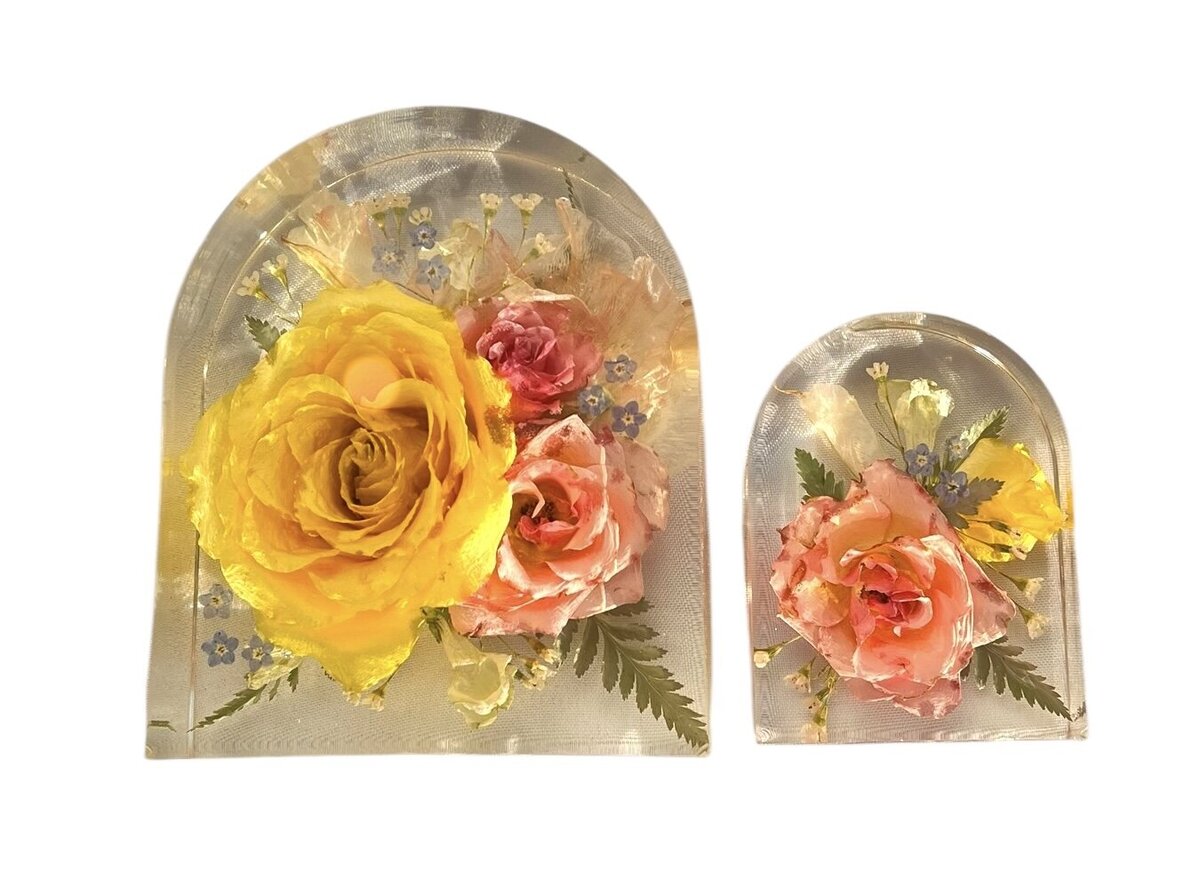 arch resin blocks with bright pink and yellow funeral flowers preserved as a family heirloom