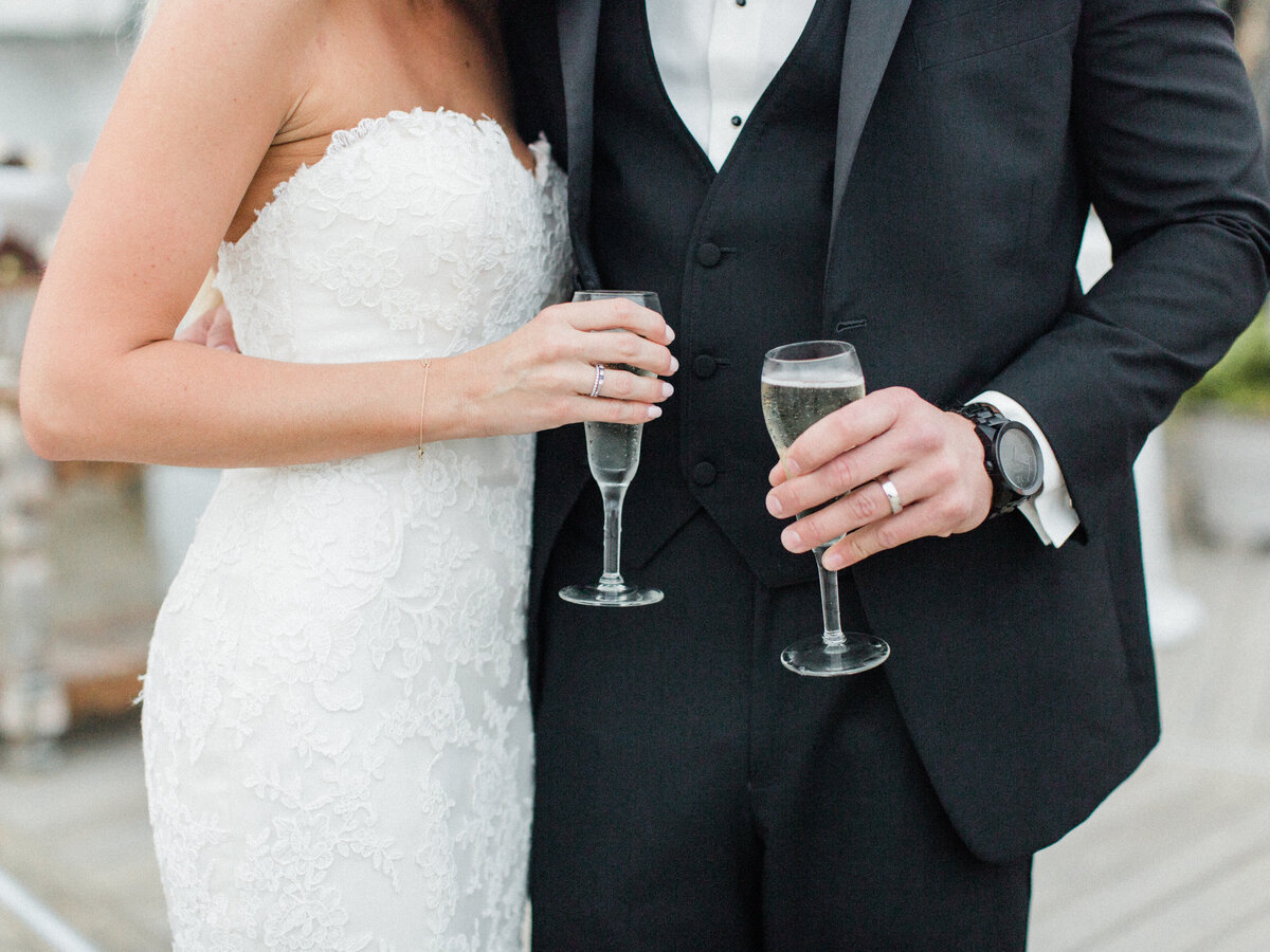 Bride and groom hold champagne glasses
