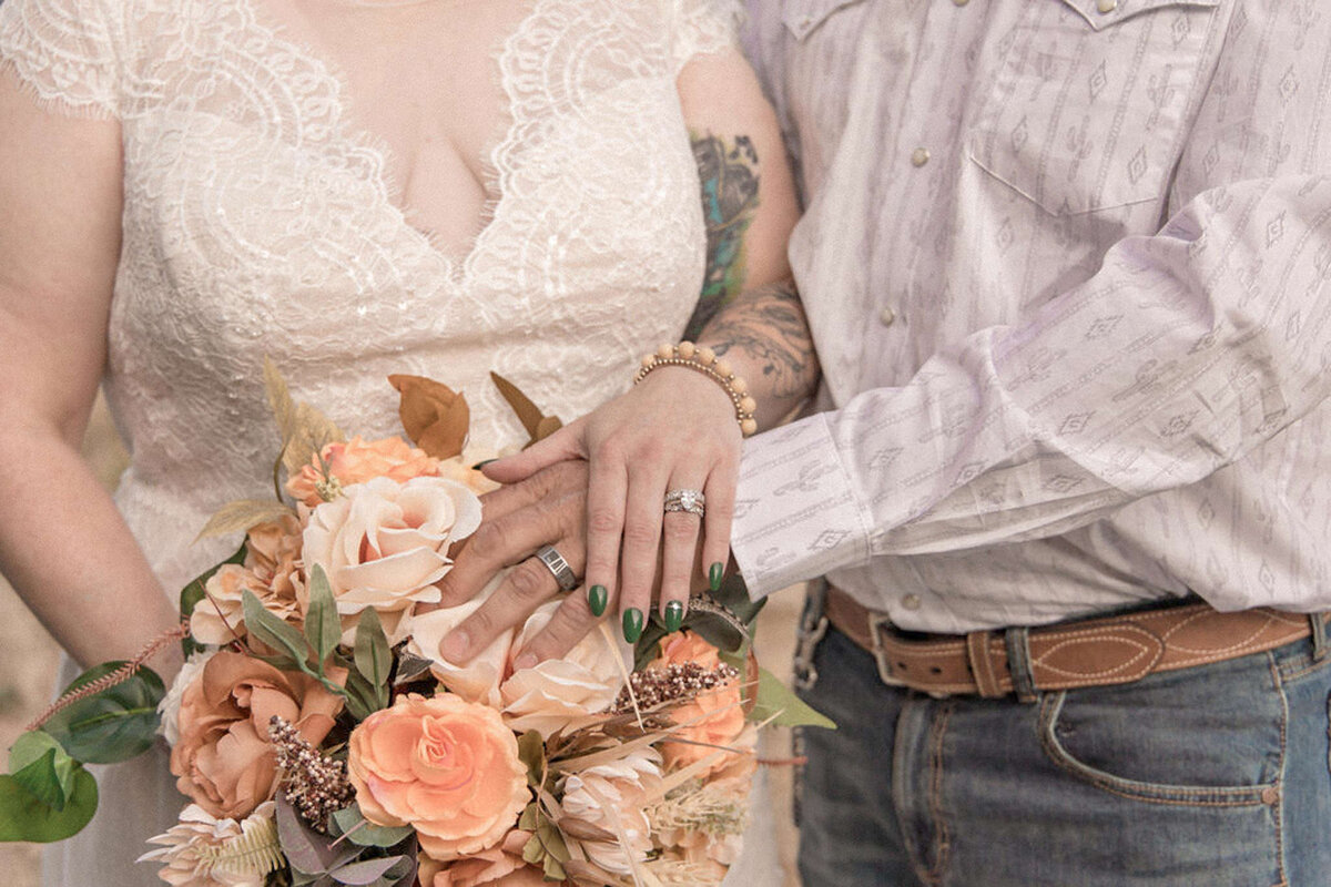 The couple display their new wedding bands atop the brides bouquet. Photographed by Stephanie Eddy, Colorado wedding photographer.